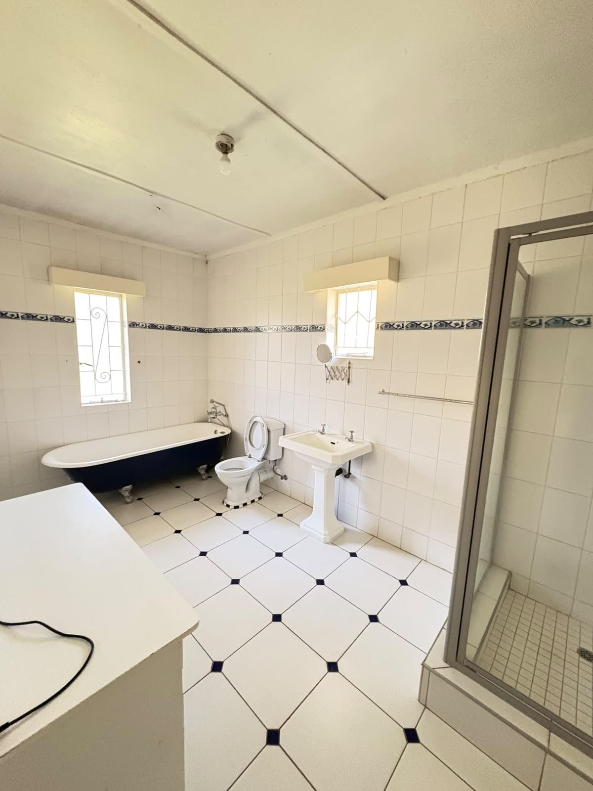 A bathroom with a bathtub, toilet, sink, and a shower area.