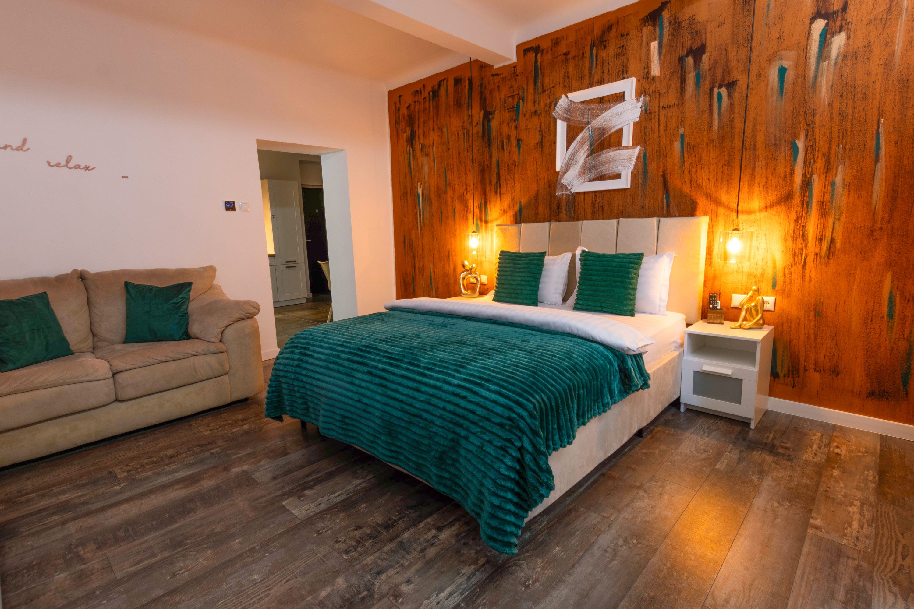 Een slaapkamer met een bed, nachtkastje, bank en een wand van hout.