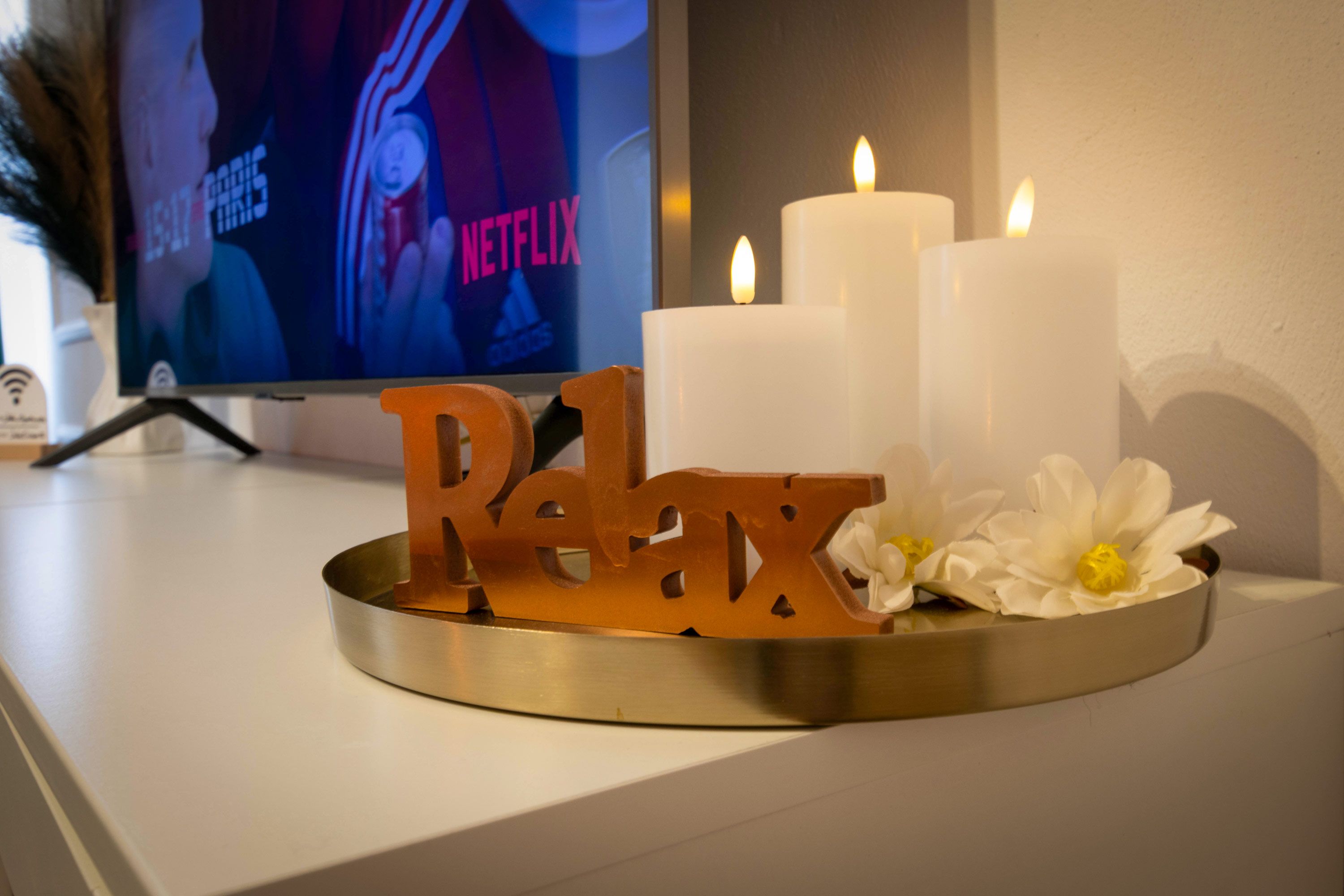 A tray with candles and a decorative sign on a white surface.