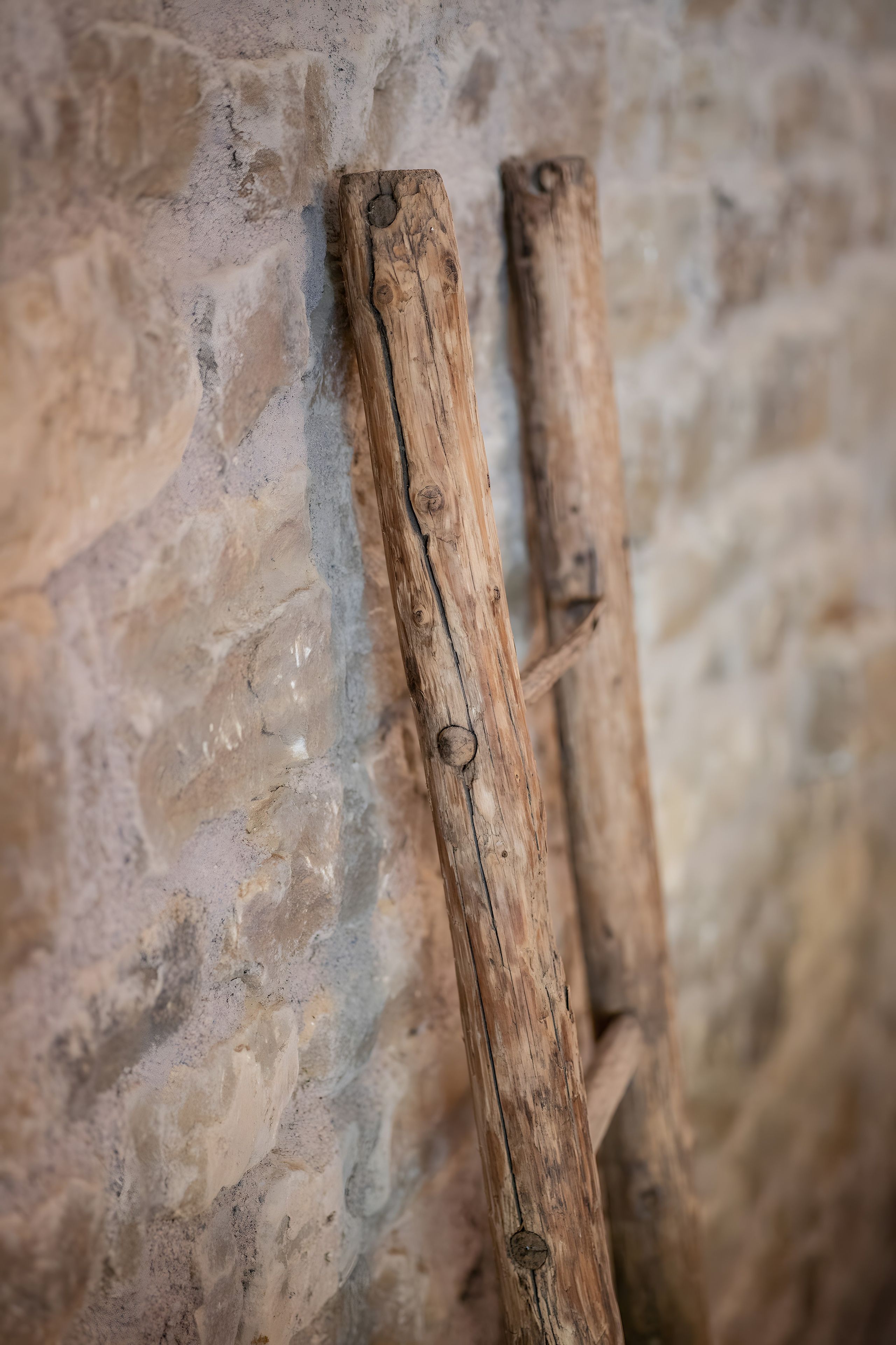 Due travi di legno appoggiate su una parete in pietra ruvida.