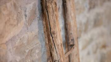 Due travi di legno appoggiate su una parete in pietra ruvida.