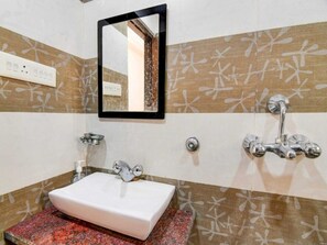 A bathroom with a white sink, a mirror, and a shower with a chrome faucet. - Deluxe PG Guest House (Barasat)