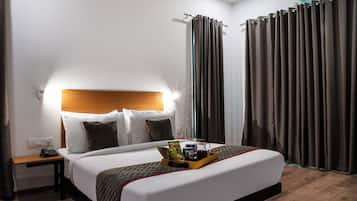 A hotel room with a bed, bedside table, and a nightstand.