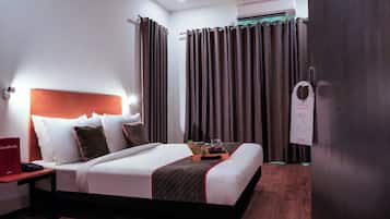 A hotel room with a bed, bedside table, and a nightstand with a telephone.
