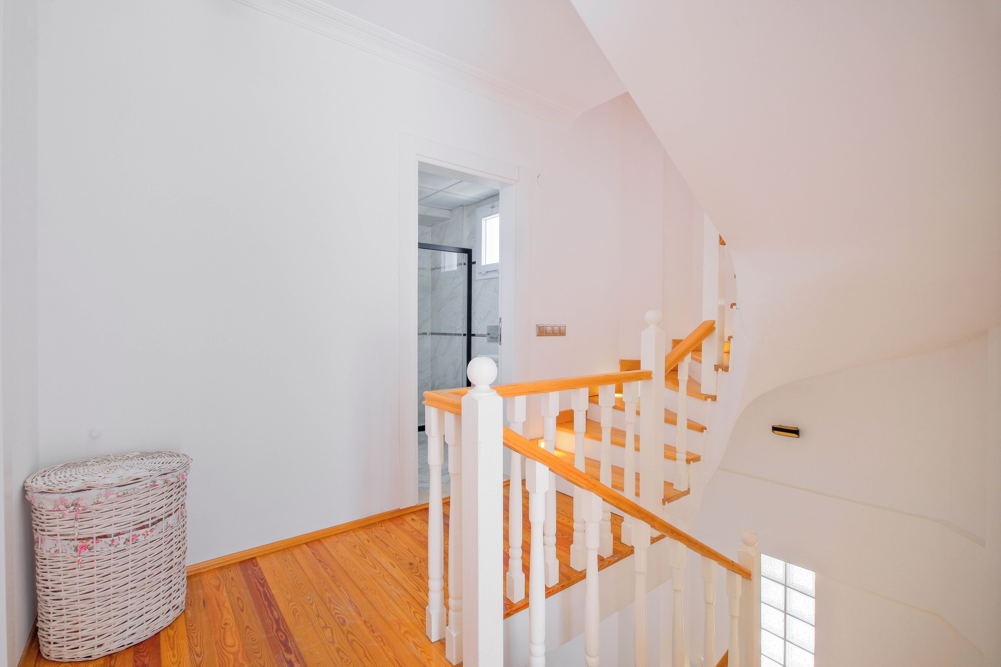 A staircase with white balusters and wooden handrails leading to an upper floor.