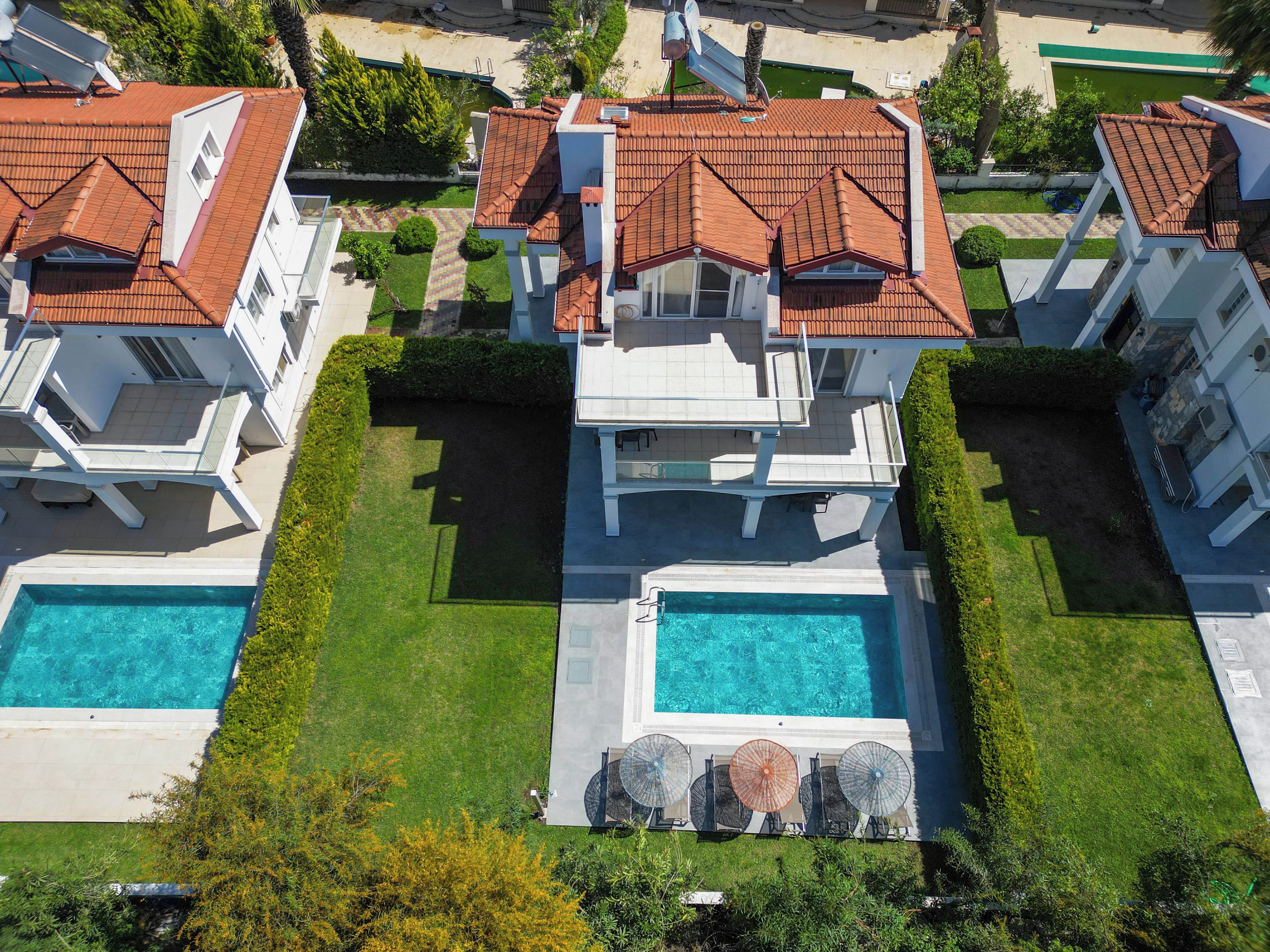 A residential property with a swimming pool, multiple balconies, and a well-maintained lawn.