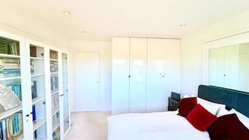 A bedroom with a bed, a wardrobe, and a bookshelf.