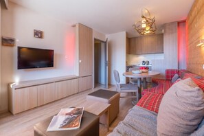 A modern living room with a flat-screen TV, a sofa, a coffee table, and a dining area with a table and chairs. - 10m from ski slopes, balcony, ski locker, 34-50m², Avoriaz (Avoriaz)
