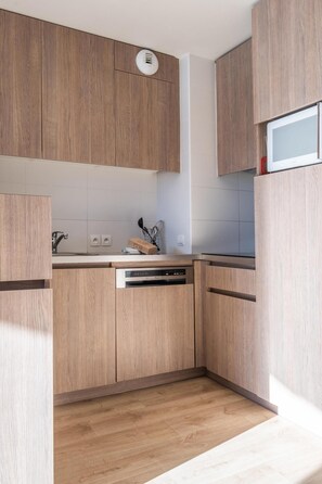 A modern kitchen with wooden cabinets, a built-in dishwasher, and a microwave. - 10m from ski slopes, balcony, ski locker, 52-62m², Avoriaz (Avoriaz)