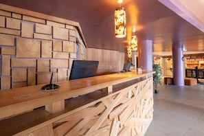 A reception desk with a laptop, a wooden wall with a brick pattern, and hanging pendant lights. - 10m from ski slopes, balcony, ski locker, 52-62m², Avoriaz (Avoriaz)