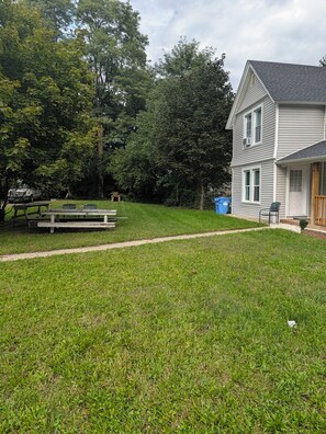 A residential property with a well-maintained lawn, a picnic table, and a house with a porch. - Quiet 3BR Retreat Near Mohegan Sun & Foxwoods (Norwich)
