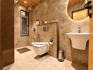 A modern bathroom with a freestanding bathtub, a toilet, and a sink.