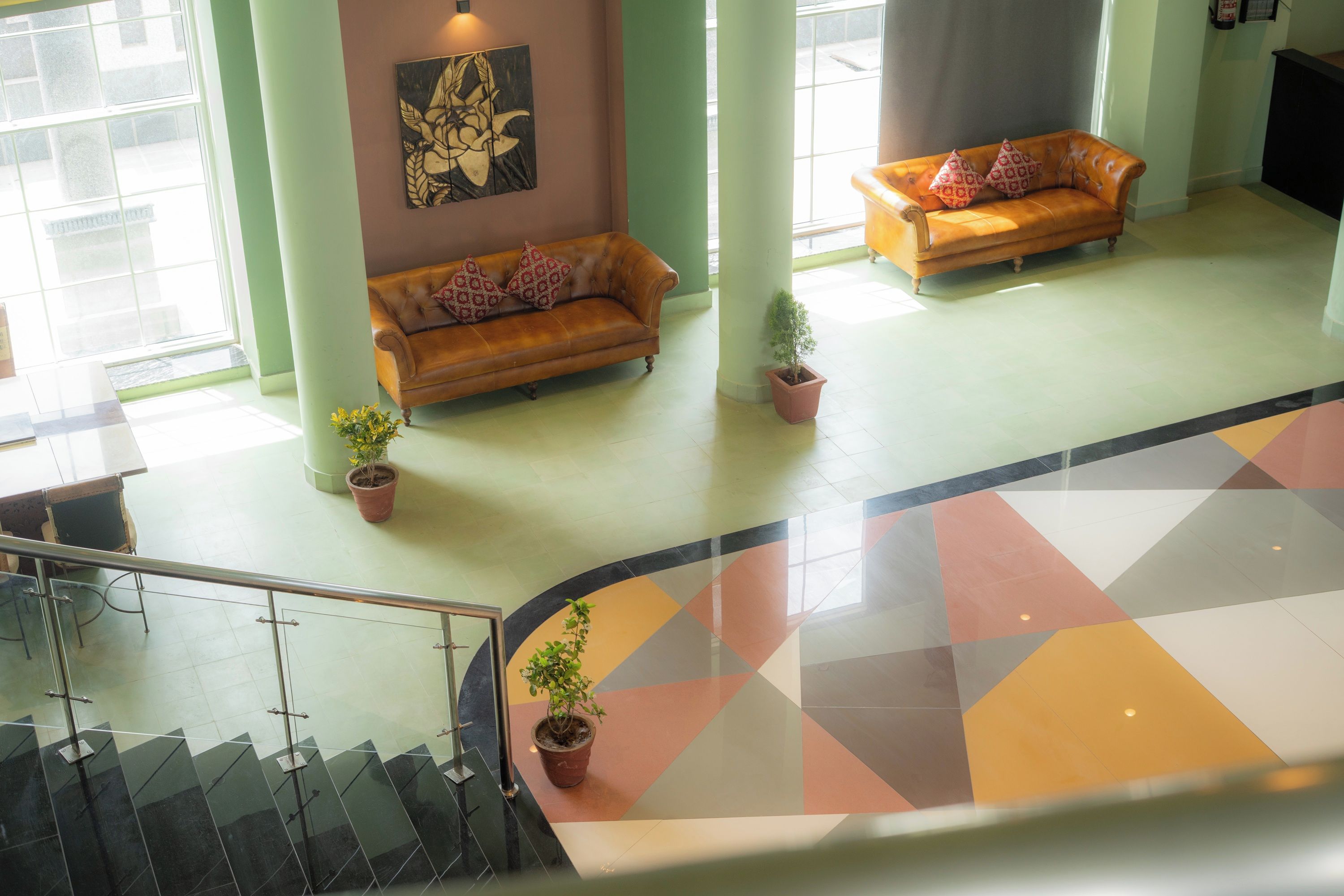 Eine Lobby mit zwei Sofas, einer Treppe und einem geometrischen Bodenmuster.
