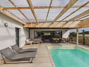 A covered outdoor area with a pool, lounge chairs, and a seating area with tables and chairs. - Studio for 4, heated pool & shared garden (Saint-Alban)