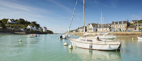 A harbor with boats docked, a building with a sign reading "CLUB", and a clear sky.
