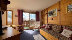 A wooden interior with a sofa, a table, and chairs. There is a sliding glass door leading to an outdoor area. - Ski-in/ski-out & foot of the slopes, 2nd floor, balcony, tv, 31m², Courchevel (Courchevel)