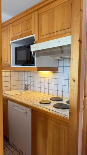 A kitchen with wooden cabinets, a microwave, a stove, and a dishwasher. - Ski-in/ski-out & foot of the slopes, 2nd floor, balcony, tv, 31m², Courchevel (Courchevel)