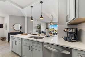 A modern kitchen with a central island, stainless steel appliances, and pendant lighting. - Vista Cay 3BR Condo with Resort Pool Balcony (Orlando)