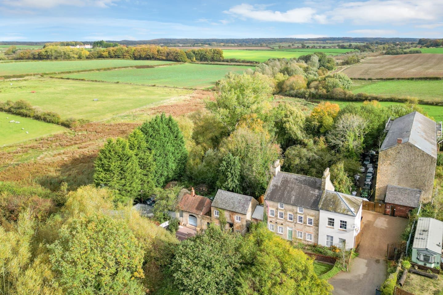 A rural property with a large house surrounded by fields and trees.