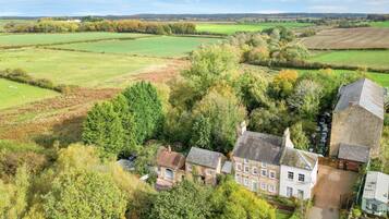 A rural property with a large house surrounded by fields and trees.