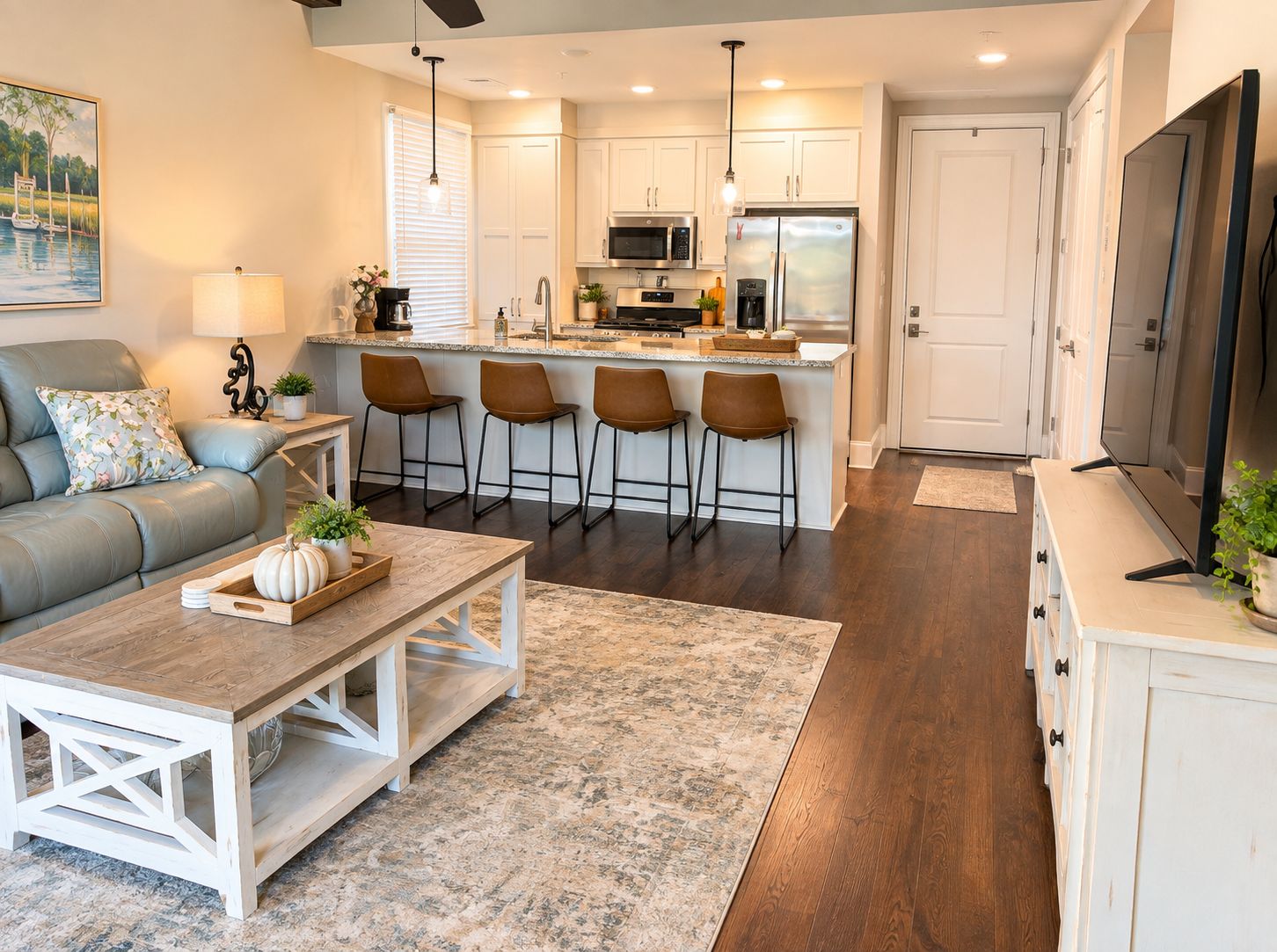 A modern kitchen with white cabinets, a central island with bar stools, and a dining area with a wooden table and chairs.