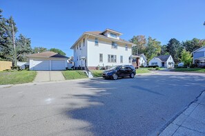A two-story residential house with a garage, a driveway, and a parked SUV. - Walkable Canton Duplex Near Fairgrounds & Dtwn! (Canton)