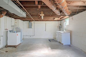 A room with exposed ceiling beams, a washing machine, a refrigerator, and a water heater. - Walkable Canton Duplex Near Fairgrounds & Dtwn! (Canton)