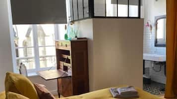 Un dormitorio con una cama, un escritorio y una ventana.