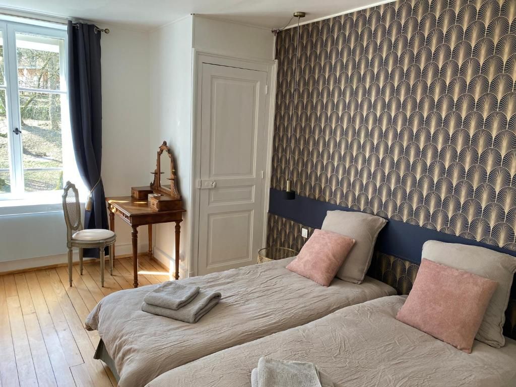 Une chambre avec deux lits, un bureau et une chaise.