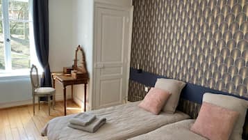 Une chambre avec deux lits, un bureau et une chaise.