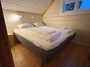 Ein Schlafzimmer mit einem Bett, Nachttischen und einem Fenster.