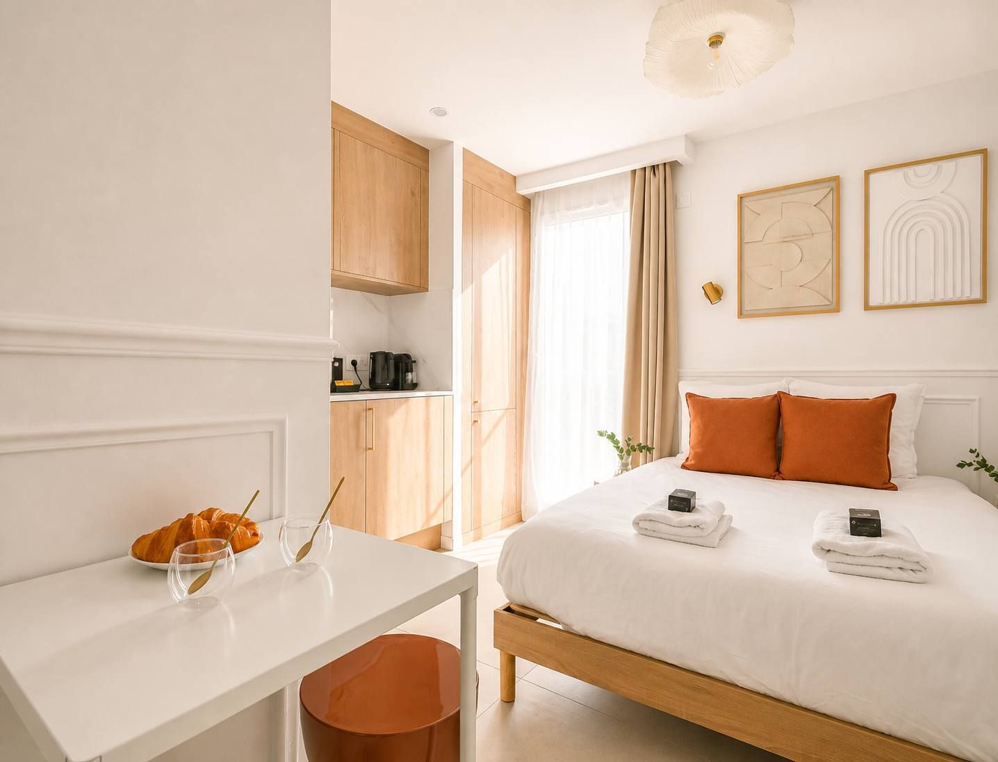 Une chambre d’hôtel comprenant un lit, une table de chevet et un coin cuisine.