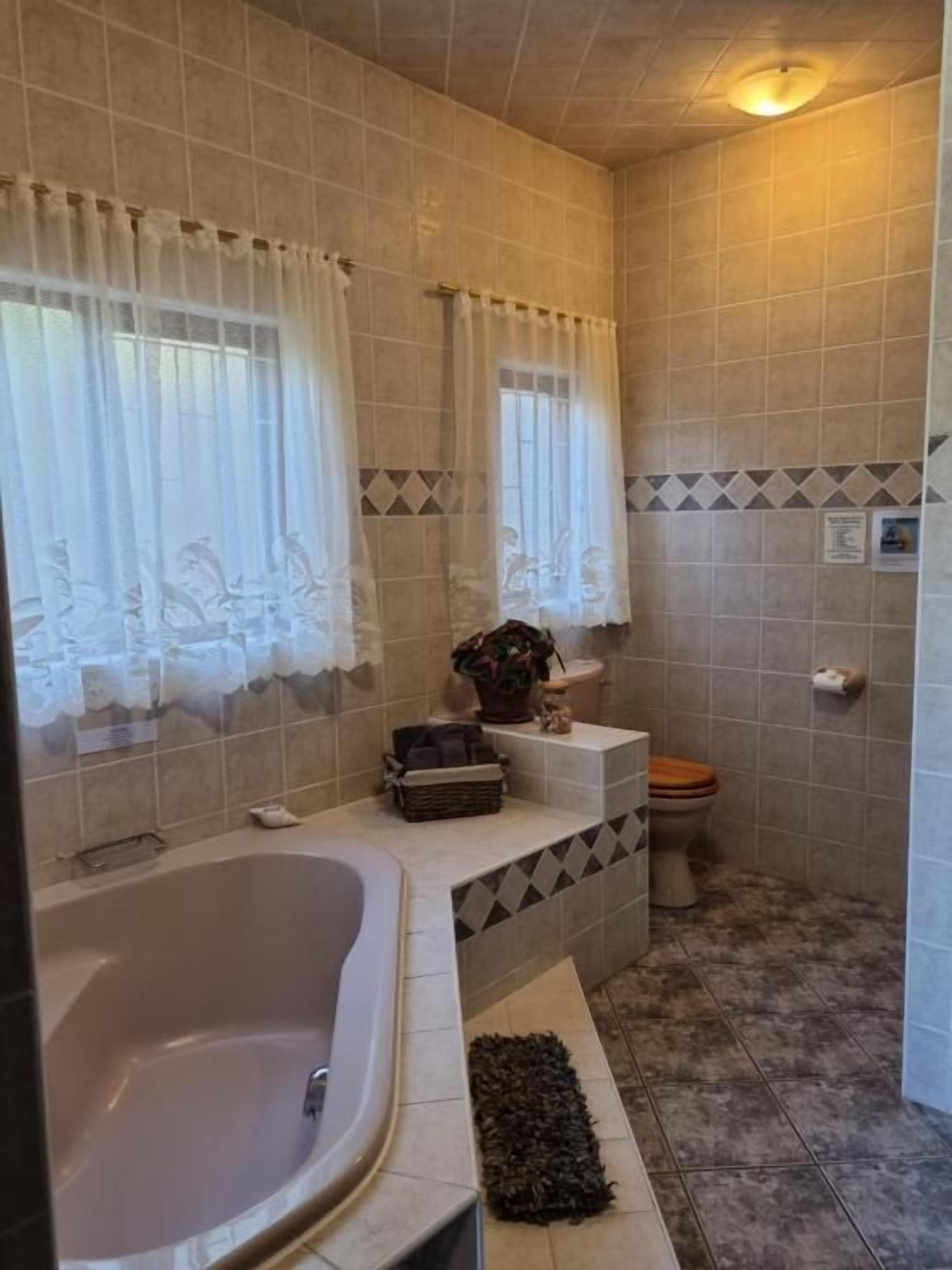 A bathroom with a bathtub, toilet, and shower area.