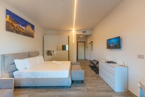 A modern hotel room with a large bed, a desk, and a television. - Hotel Lagorá (San Giuliano Milanese)