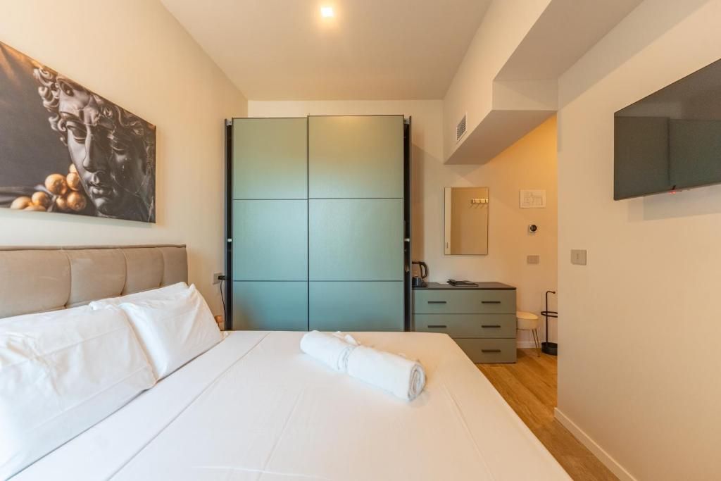 Ein Hotelzimmer mit einem Bett, einem Schrank, einem Schreibtisch und einem Fernseher.