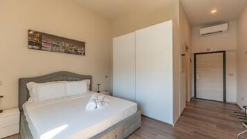 Une chambre à coucher avec un lit, une armoire, un tableau et un appareil de climatisation.