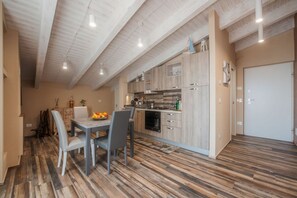 Eine moderne Küche mit Holzschränken, einem Esstisch mit Stühlen und einer Obstschale.