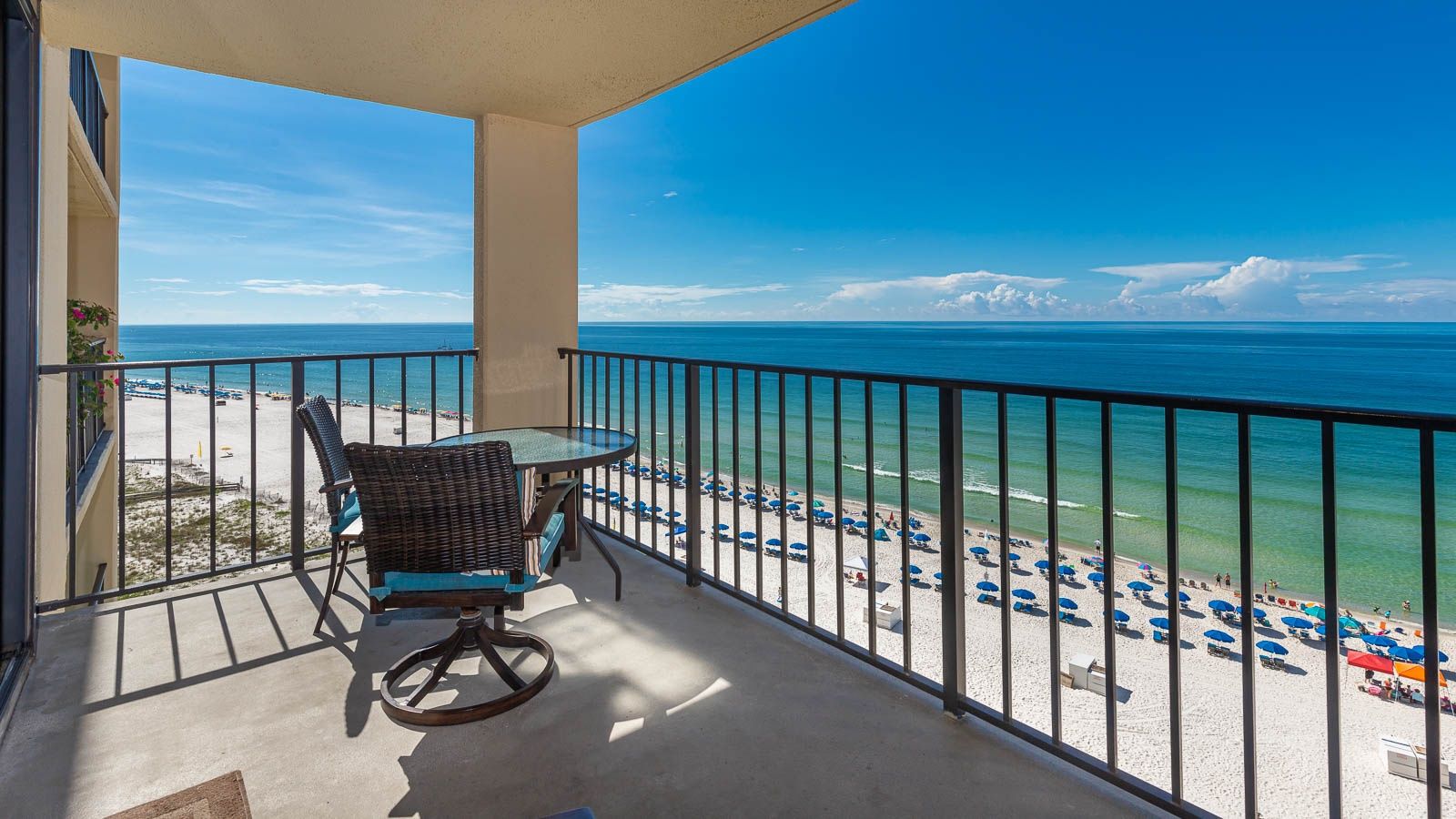 A balcony with a view of a beach and ocean.