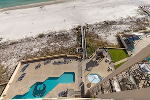 A rooftop pool area with a view of the beach, a lifeguard tower, and a covered seating area. - Phoenix Ii 2124 1 Bedroom Condo (Orange Beach)