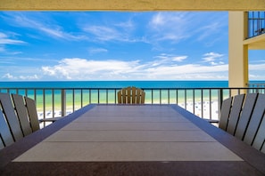 Ein Balkon mit Blick auf Strand und Meer.