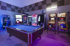 A pool table in the center with arcade games around it. - Phoenix Ii 2047 2 Bedroom Condo (Orange Beach)