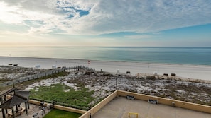 A beach view with a wooden walkway, a flag, and a fenced area with benches. - Phoenix Ii 2047 2 Bedroom Condo (Orange Beach)