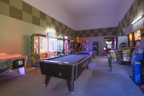 A room with a pool table, arcade games, and a checkered wall. - Phoenix Ii 2048 3 Bedroom Condo (Orange Beach)