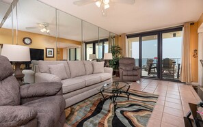 A living room with a sofa, armchair, and a glass coffee table. - Phoenix Ii 2036 1 Bedroom Condo (Orange Beach)