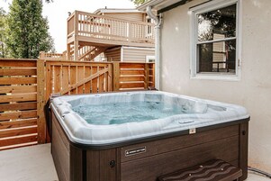 Un jacuzzi con terraza de madera y ventana.