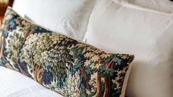 A bed with white pillows and a patterned throw pillow.