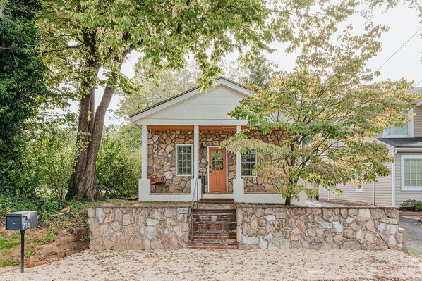 A house with a stone facade, a wooden front door, and a mailbox. - The 1st Street Bungalow (Charlottesville)