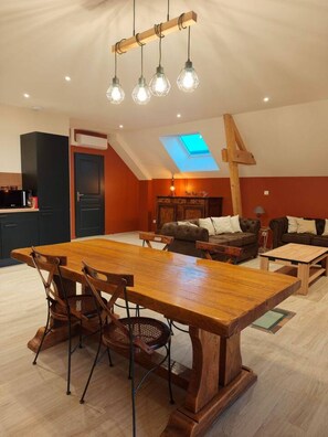 Ein großzügiges Loft mit Essbereich, einer Sofaecke und einem Oberlicht.