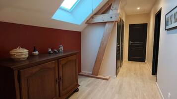 Un couloir doté d’une lucarne, d’un plancher en bois et d’une armoire en bois foncé.