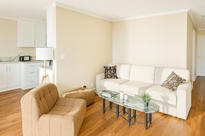 A living room with a sofa, ottoman, and coffee table. - Ocean Haven | Beachfront Getaway by Redondo Pier (Redondo Beach)